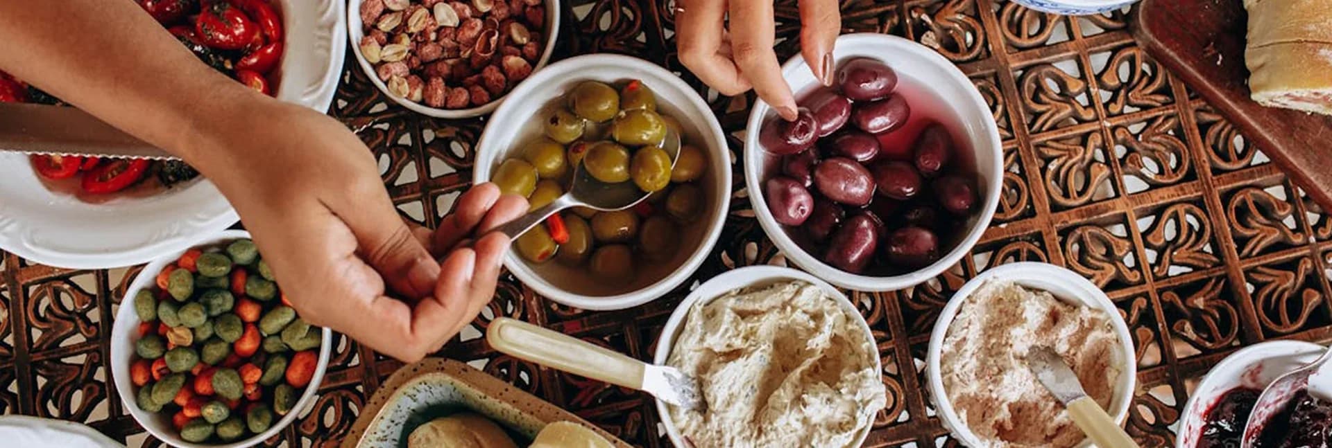 Bowls of olives, nuts, and dips on a table